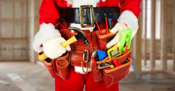 Santa Worker with a tool belt construction background.